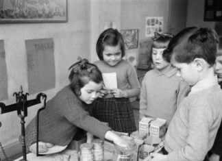 忘れ去られたD-Day:追憶と忘却〔第9部〕 私たちは子供のころからお金の価値を学んできました。例えば、1944年12月、ケンブリッジシャーの写真の子供たちのように、食料品を購入する際、どれほどのお金でどれ位の買い物ができるか、遊びながら学んでいるのです。この子供たちは27年後、新しい貨幣システムに容易に慣れることができたでしょうか? 写真: Imperial War Museum / Public Domain